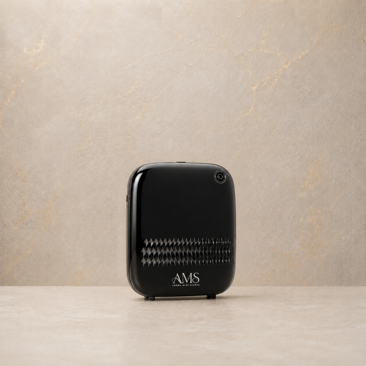 A black AMS diffuser with a glossy finish and a textured front grille, standing on a light beige surface against a textured beige wall.