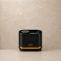 A sleek black cylindrical diffuser with gold lettering that reads 'AMS' and 'AMERICA'S MUSIC' on the front, set against a textured beige marble background.
