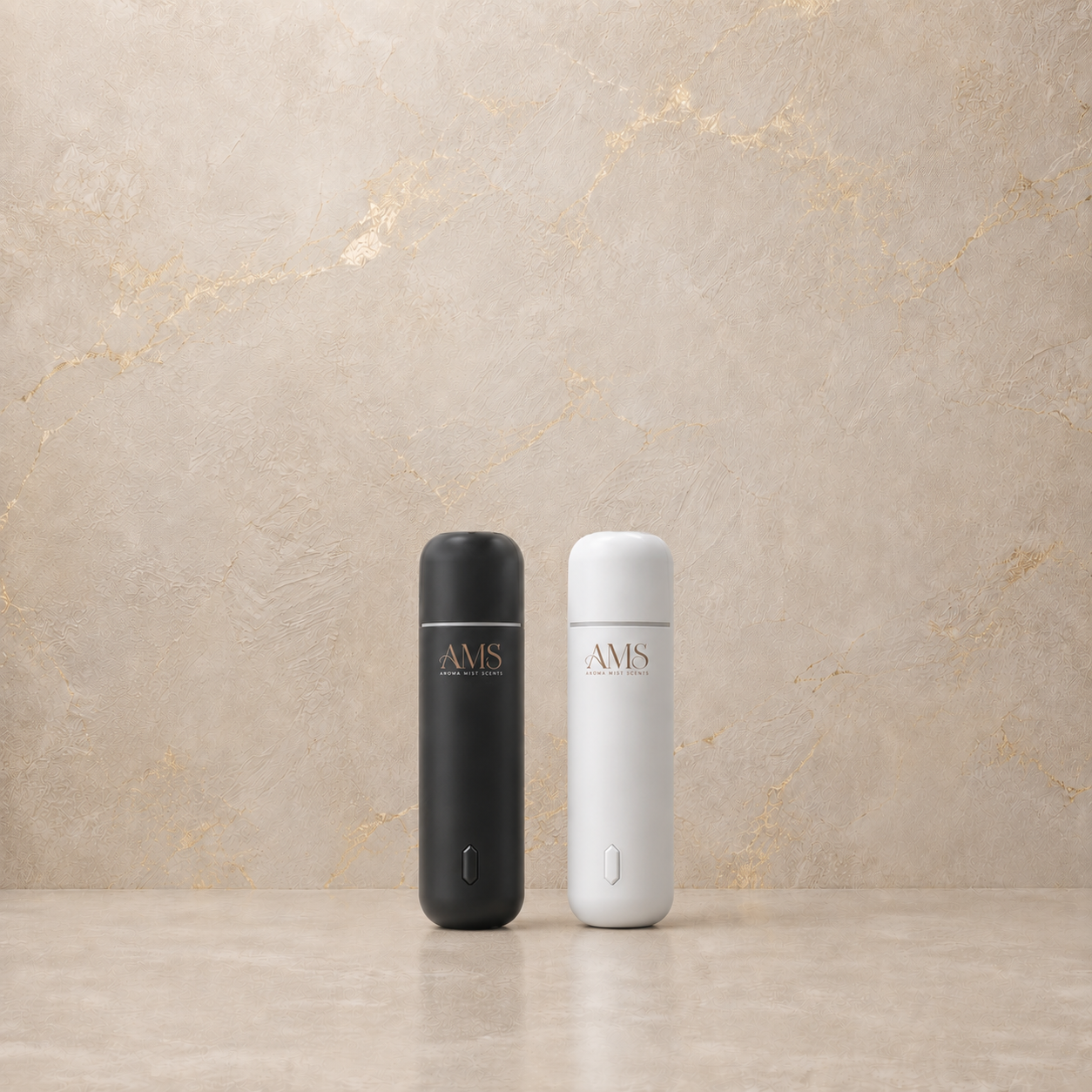 Two slim cylindrical portable diffusers standing upright on a light stone surface against a beige marble-look wall. One device is matte black and the other is matte white, both with the AMS logo printed on the front.
